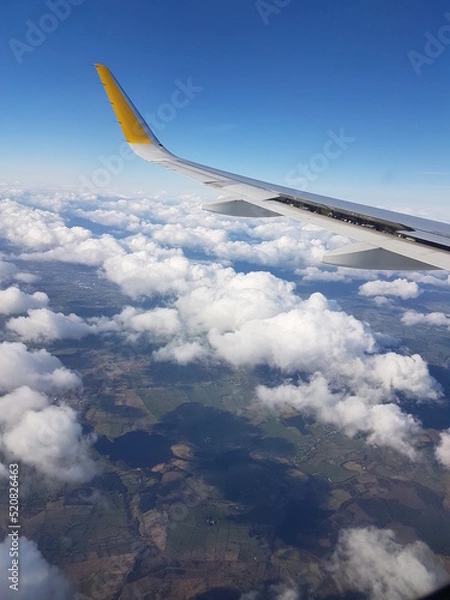Fototapeta View from airplane window in a cloudy day