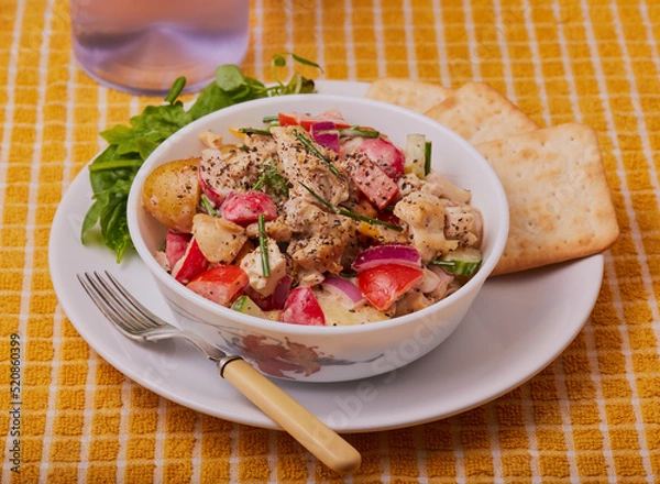Fototapeta Chicken and potato sald in a white bowl with crackers.
