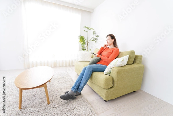 Fototapeta 家でテレビを見る女性
