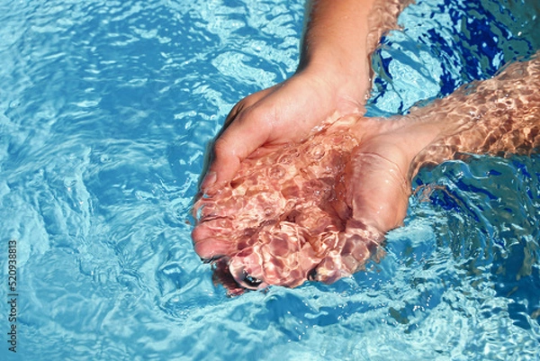 Fototapeta The hands cupped together submerged in clean clear blue water in swimming pool