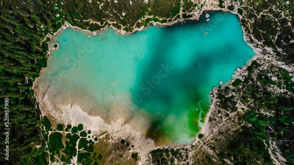 Fototapeta Lago di Sorapiss from above,beautiful mountain lake in Dolomite Alps,Italy.Turquoise color water is dust from the glacier.crystal clear water top down view.Drone nature,alpine forest