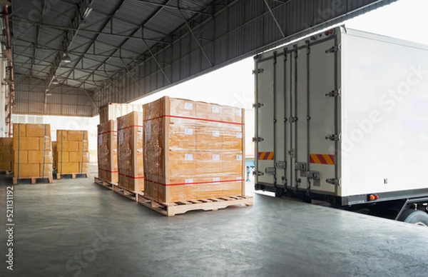 Fototapeta Packaging Boxes Wrapped Plastic Stacked on Pallets Loading into Cargo Container. Delivery Shipping Trucks. Supply Chain Shipment. Distribution Supplies Warehouse. Freight Truck Transport Logistics.	