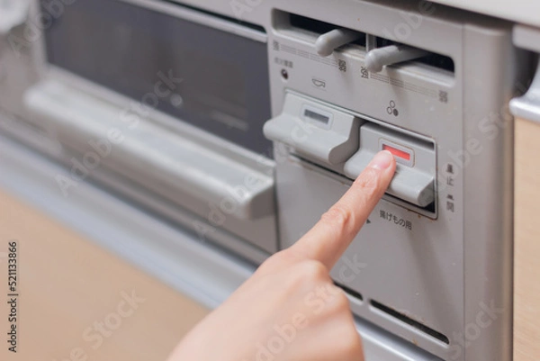 Obraz ガスコンロのスイッチを押す女性