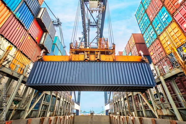 Fototapeta Industrial crane loading Containers in a Cargo freight ship. Container ship in import and export business logistic company. Container background for logistic and transportation concept.