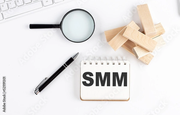 Fototapeta SMM word written on notebook with block magnifier and pen , business concept.