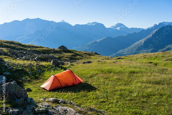 Obraz Red tent on a beautiful, tranquil campsite in the Swiss mountains.