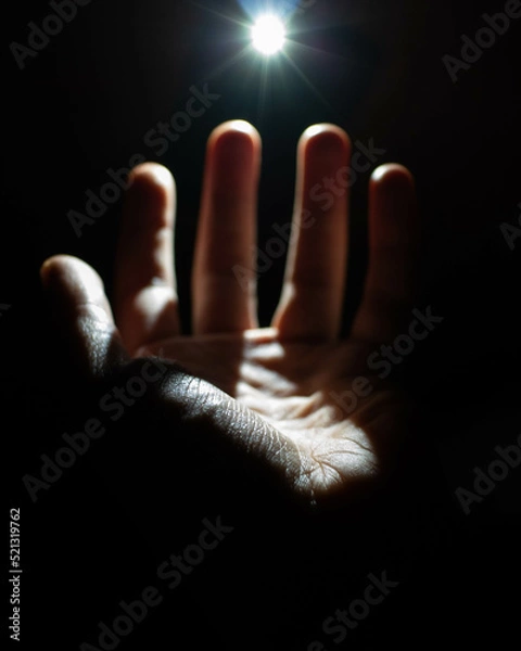 Obraz hand reaching toward light