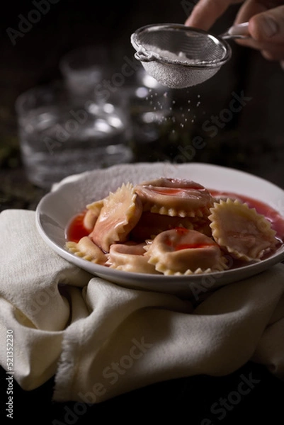Fototapeta Dumpling with sugar, on a dark background, food photography.