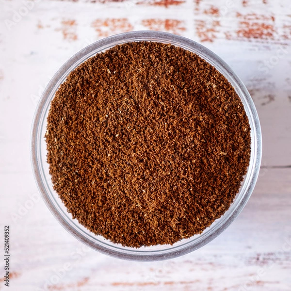 Fototapeta Close-up view of freshly ground coffee on a rustic white table