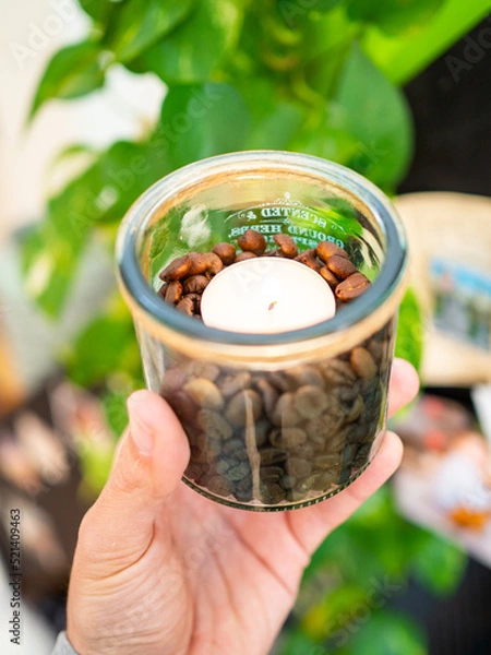 Obraz Lit candle filled with coffee beans