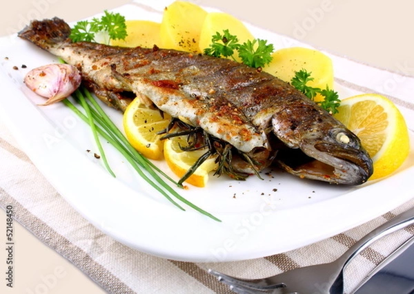 Fototapeta Grillowany pstrąg w całości z ziemniakami, cytryną i czosnkiem