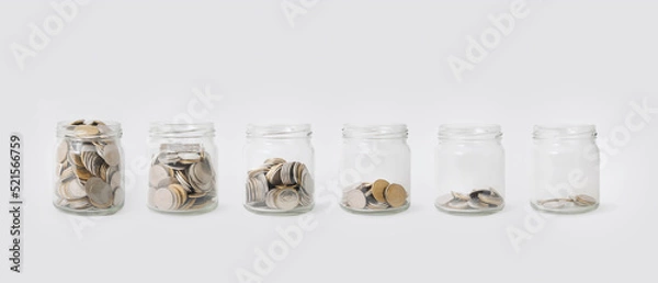Fototapeta Glass jars with coins.Concept background for business,finance,.savings.Color toned in clean pastel.