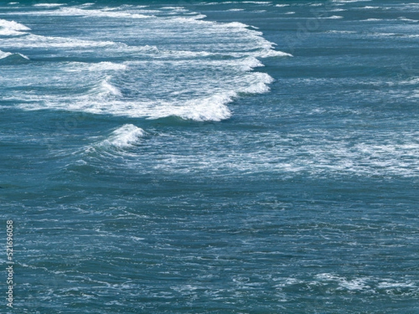 Fototapeta Beautiful white foam on turquoise tidal waves. The surface of the water as a background. Blue ocean water