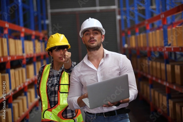 Fototapeta worker in warehouse,  using bar code scanner to scanning box and analyze newly arrived goods.  Working at warehouse.International export business concept