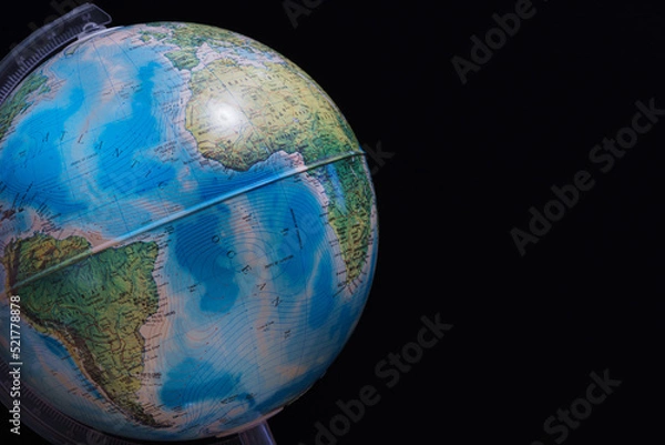 Fototapeta World globe set against a dark black board background. Concept image with copy space available.