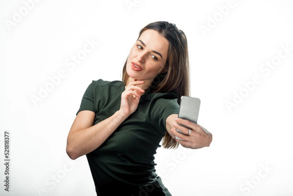Fototapeta Model charming person with smartphone. Young pretty lady doing selfie in studio.