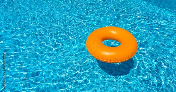 Fototapeta Orange ring floating in blue swimming pool. Inflatable ring, rest concept