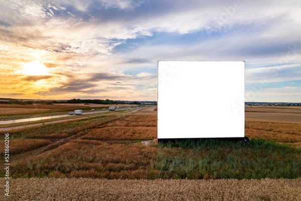 Fototapeta Aerial drone shot of big blank billboard near busy highway or motorway at sunset