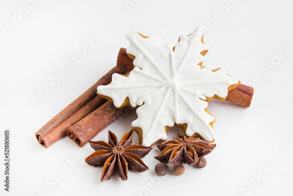 Fototapeta Christmas and New Year holidays. Gingerbread and spices on a white background. Winter traditions. Christmas greeting. Preparation for a holiday postcard. Top view.