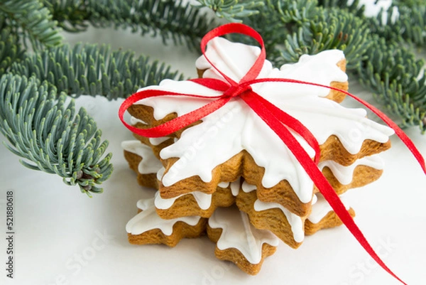 Fototapeta Gingerbread cookies tied with a red ribbon. Christmas and New Year holidays. Winter traditions. Christmas greeting. Preparation for a holiday postcard.