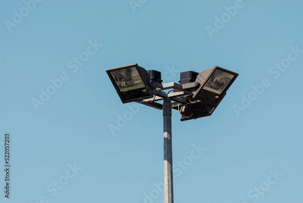 Fototapeta High halogen lamp on a metallic pillar against blue backdrop