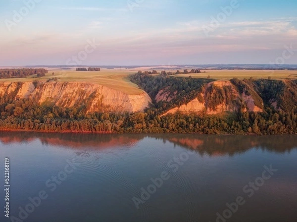Obraz Clay coast with groves of birch trees, soil erosion, sunset clouds and the Ob riverbed