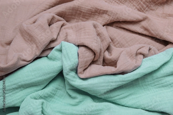 Fototapeta Light brown and green muslin, soft cotton fabric crumpled with folds close-up, with empty space for text, copy space, concept  eco-friendly clothing and textiles, eco-friendly clothing, soft washing 