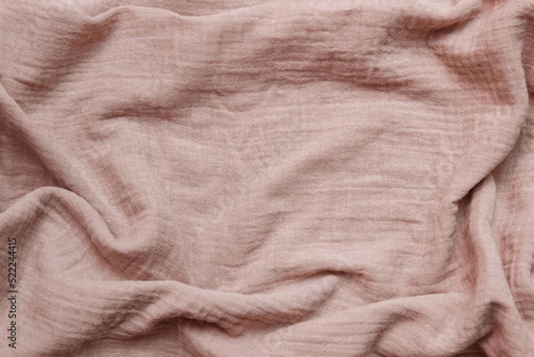 Fototapeta Light brown-pink cotton muslin fabric close-up with empty space for text, copy space, crumpled and with folds, conception of abstract backgrounds, making clothes from natural materials, linen,  sewing