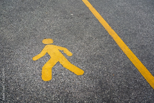 Fototapeta A pedestrain walking lane with human icon on asphalt road surface. Transportation symbol for safety background concept.