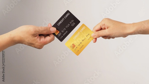 Fototapeta Two hands is hold black and gold credit card on white background.