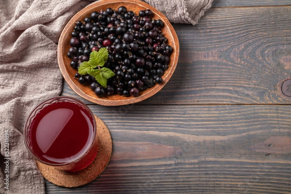 Fototapeta blackcurrant compote in a glass and berries on a table top view