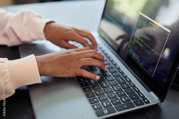 Obraz Close up of child using laptop in engineering class and programming robots, copy space