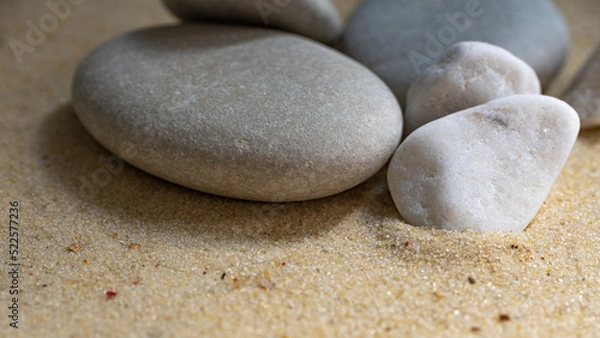 Fototapeta small gray pebbles on a sandy beach, close shot