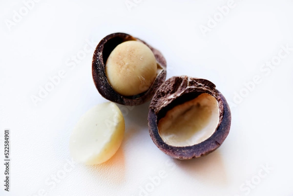 Fototapeta Whole nut and Macadamia kernel on a white background. Delicious whole nuts.