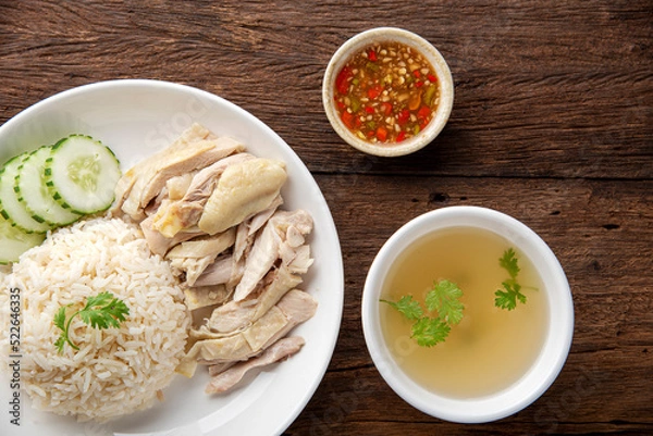 Fototapeta Hainanese chicken rice with soup on dark wooden table background. thaifood concept.
