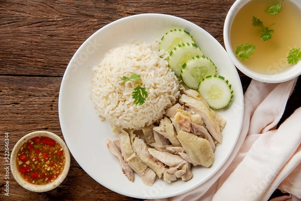 Fototapeta Hainanese chicken rice with soup on dark wooden table background. thaifood concept.