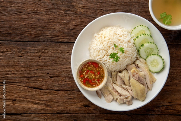 Fototapeta Hainanese chicken rice with soup on dark wooden table background. thaifood concept.