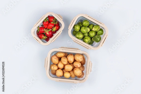 Fototapeta Glass boxes with fresh raw vegetables.  Vegetables and fruits in glass containers. Food storage concept