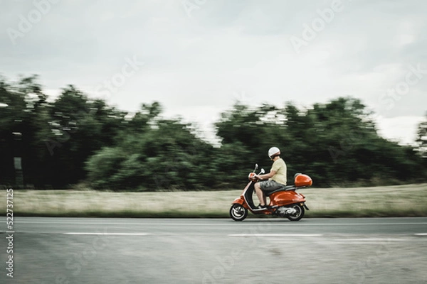 Obraz man drives a scooter