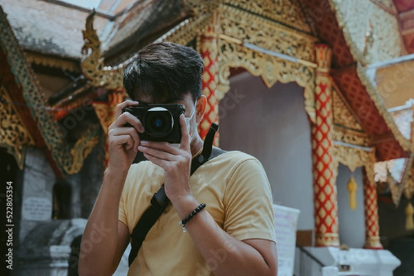 Fototapeta Front view point of young man traveller and photographer in temple yellow theme