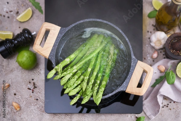 Obraz Cooking asparagus in a pot - Fresh asparagus boiled on water