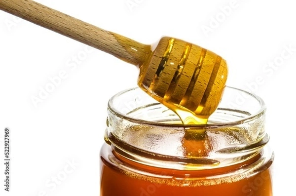 Fototapeta Honey in a glass jar with wooden honey dipper