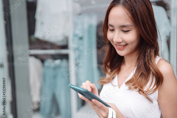 Obraz Beautiful asian female woman girl use smartphone and holding shopping bags, Walk enjoy smiling while doing shopping outside of department store malls window outdoors fashion lifestyle