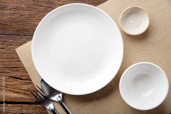 Fototapeta empty plate spoon fork on table. Table setting on wooden table background