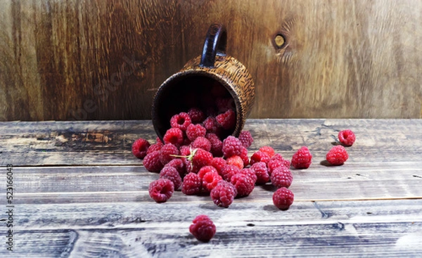 Obraz Raspberries in a wooden glass on a wooden background