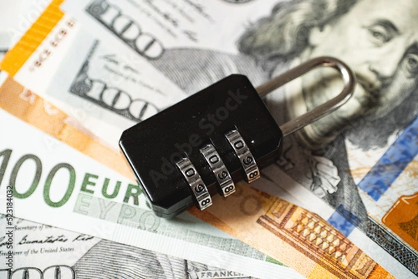 Fototapeta The concept of protection of funds, assets and capitals. The lock lies on money.
