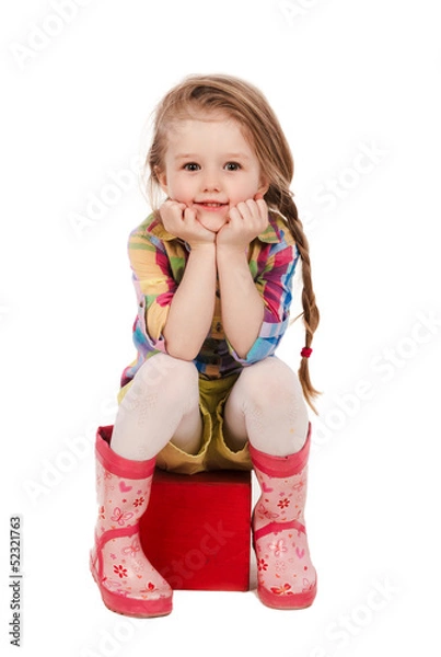 Fototapeta little girl sitting on the cube, isolated