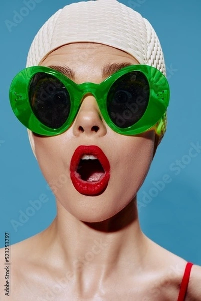 Obraz A large portrait of a shocked swimmer in a swimming cap on a blue background. Cool banner
