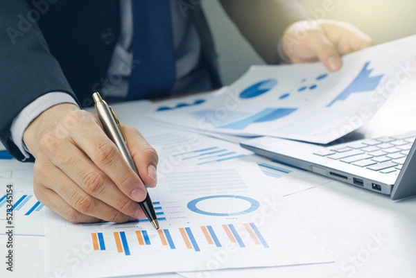 Fototapeta Business man analyzing chart and graph showing changes on the market.On the table in the office, the concept of calculating investment results