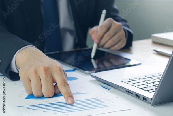 Fototapeta Business man analyzing chart and graph showing changes on the market.On the table in the office, the concept of calculating investment results